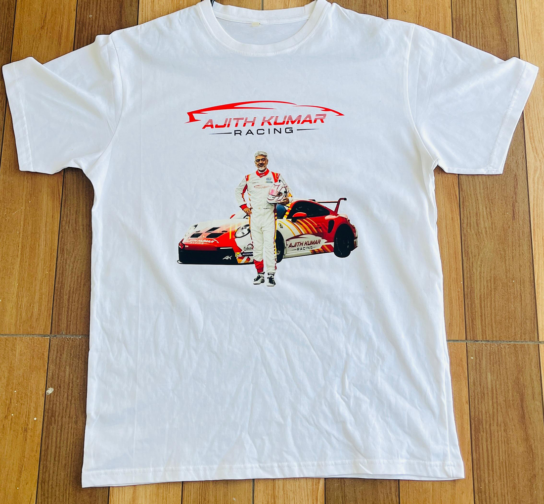Graphic T-shirt featuring Ajith Kumar in a dynamic racing pose, designed with bold colors and sleek racing elements, perfect for fans of the Tamil superstar and motorsport enthusiasts