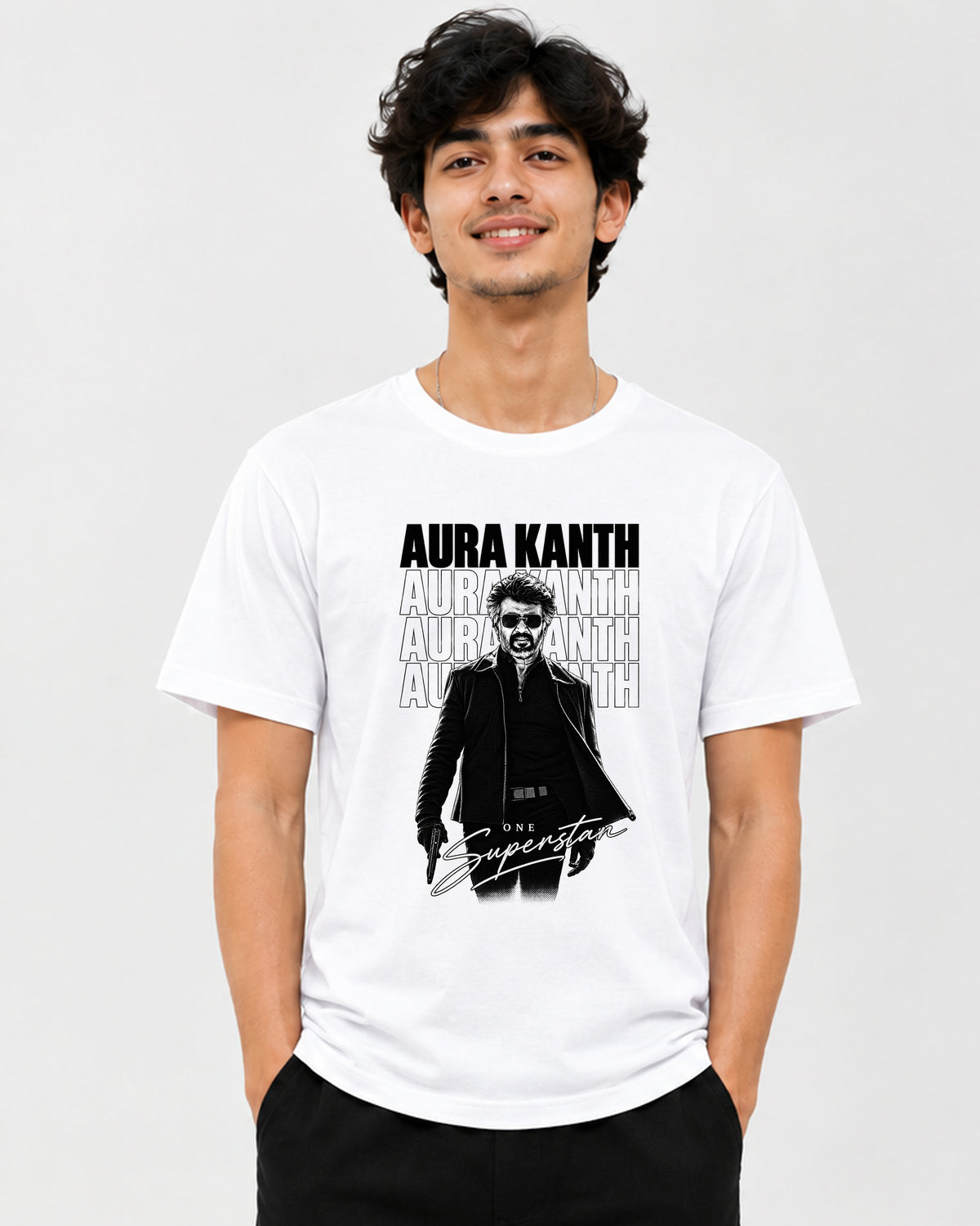 A man wearing a white graphic t-shirt with a black and gray print of a man in sunglasses and the text 'AURA KANTH' and 'The Superstar', against a light gray background.